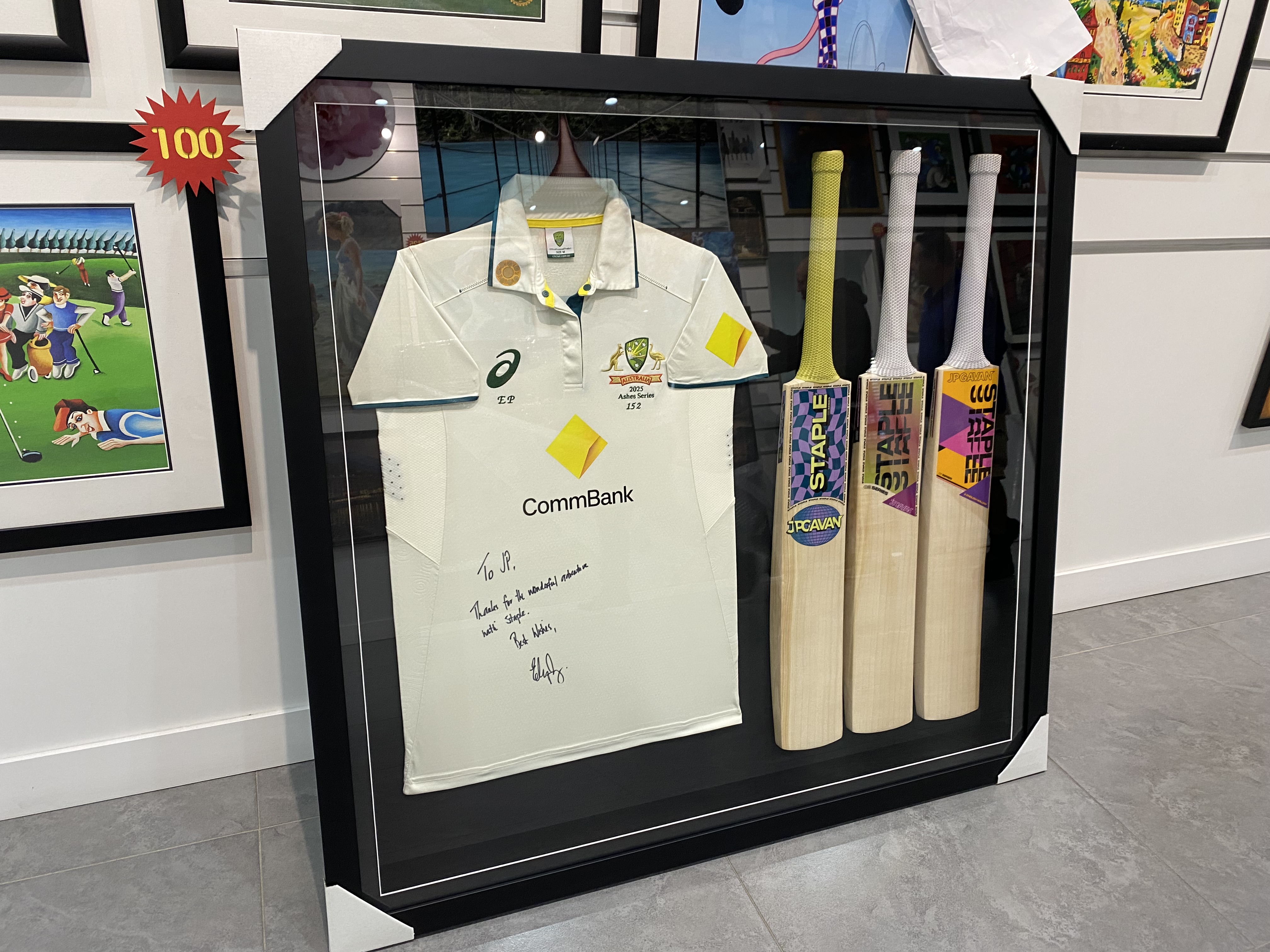 Large shadow box frame combining a signed cricket jersey and cricket bats